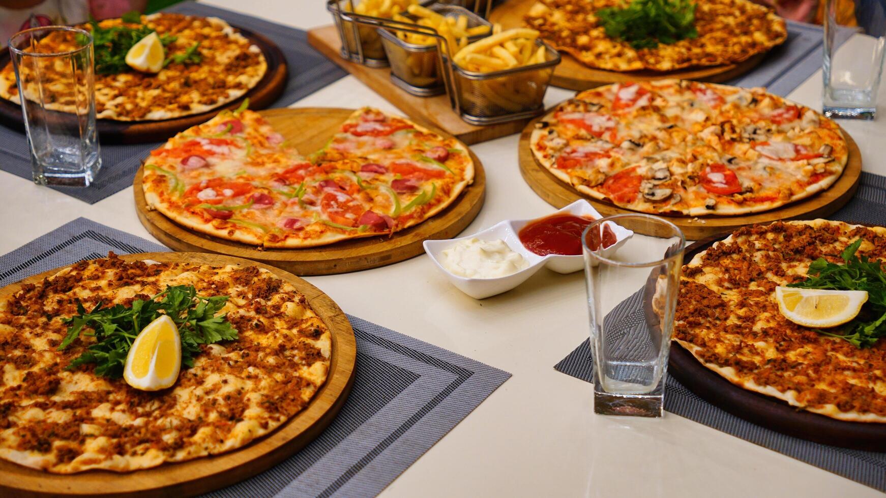 Variety of Pizzas on Table With Drinks and Fries photo