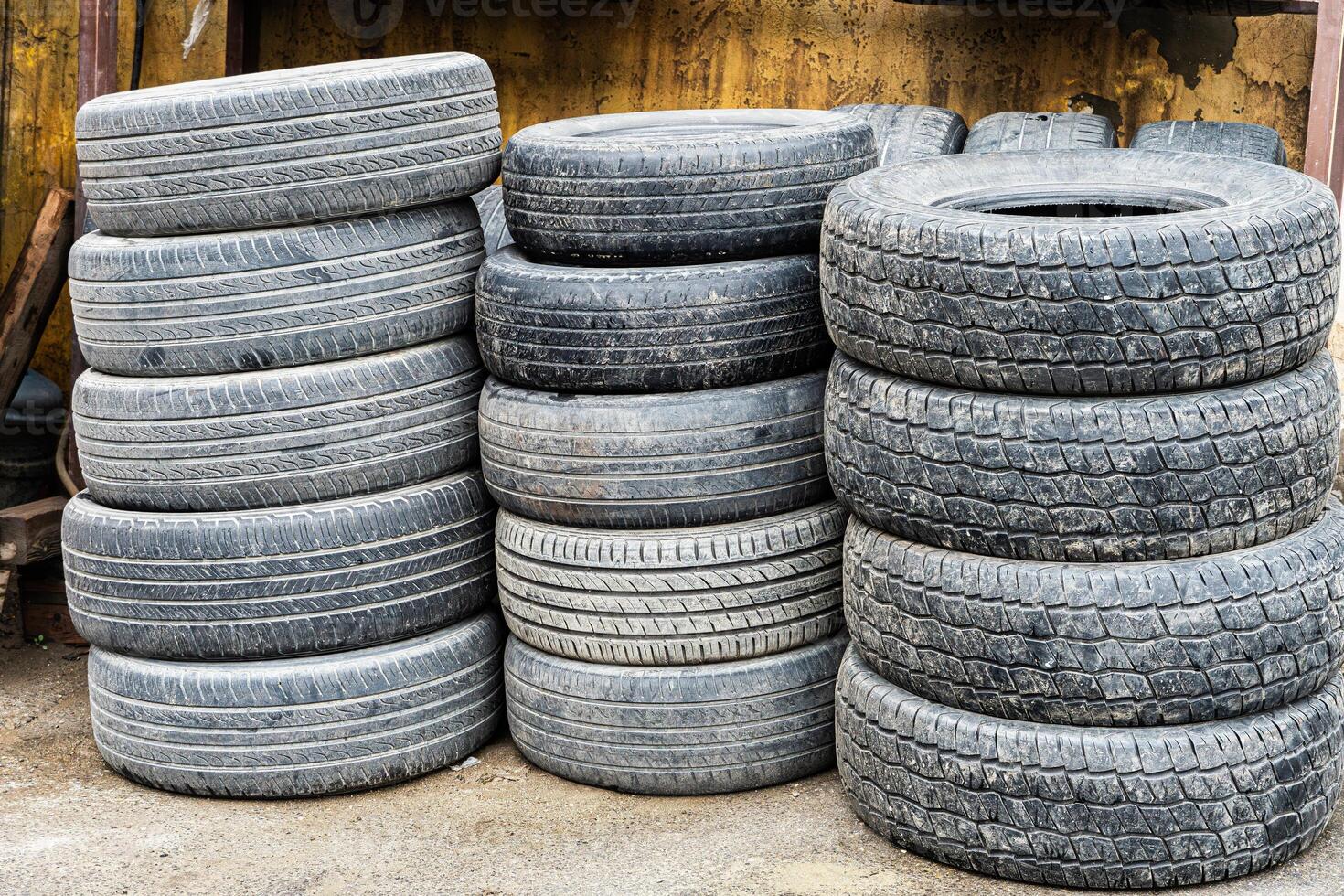 Stacked Used Tires Outside Building photo