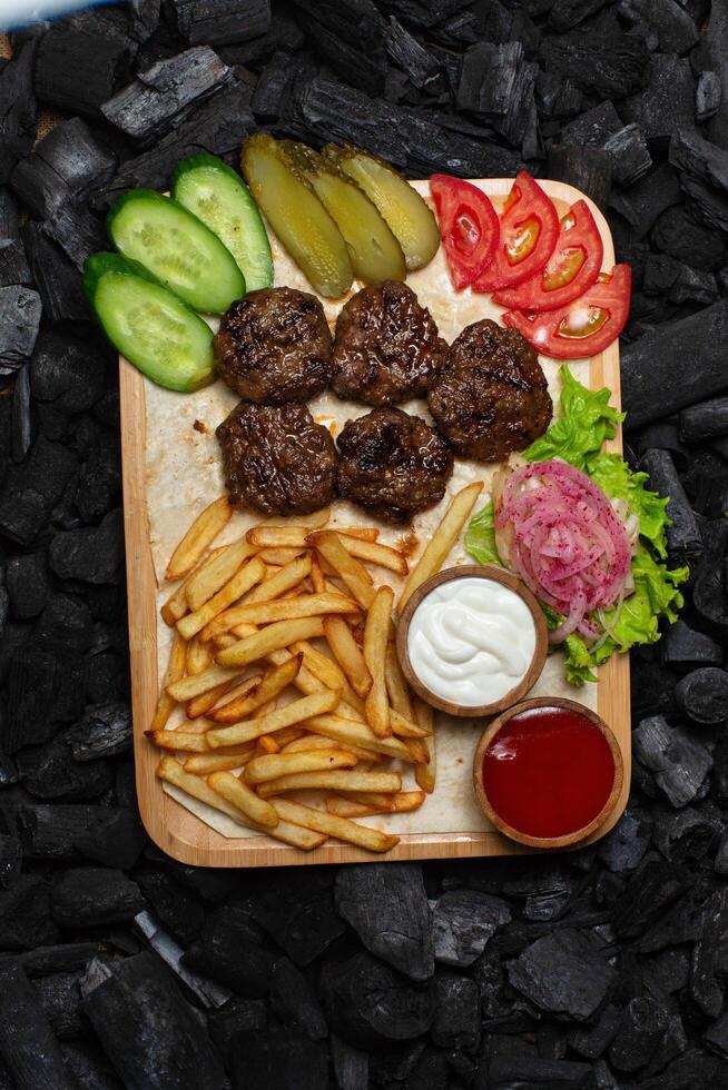 Grilled Meatballs With Fries and Sides photo