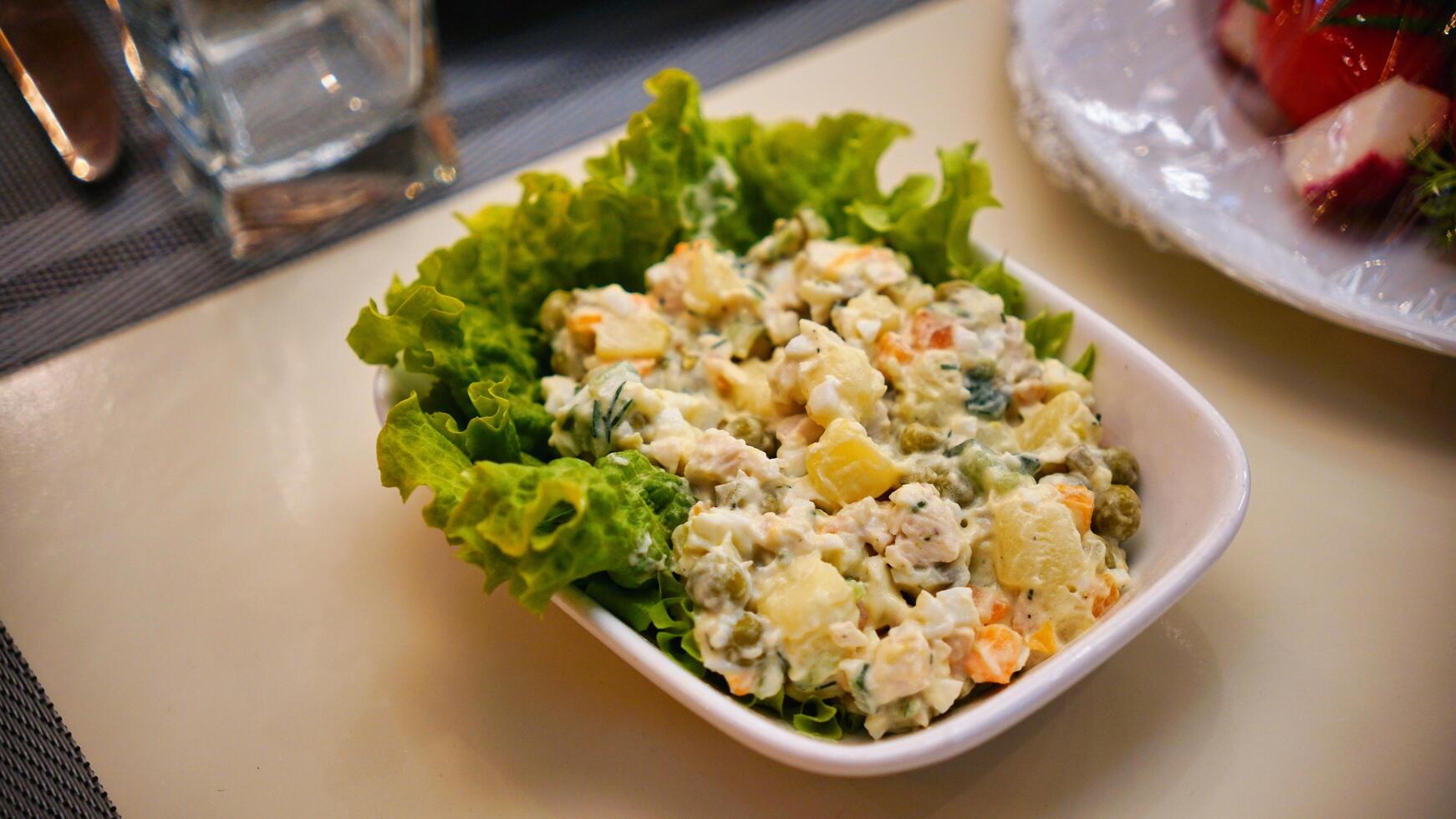 Russian Salad With Lettuce in a White Bowl photo