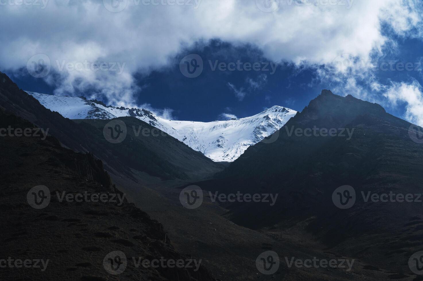 mountain peaks of glaciers with snow on the background of blue sky with clouds photo