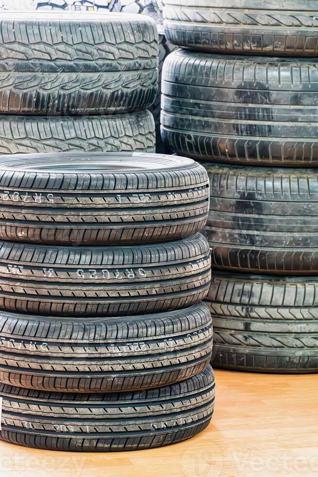 Stacked Used Car Tires on Wood Floor photo