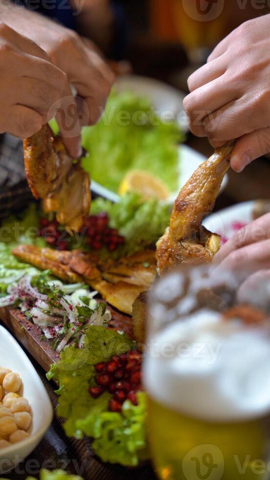 Hands Grasping Roasted Chicken and Salad With Beer photo