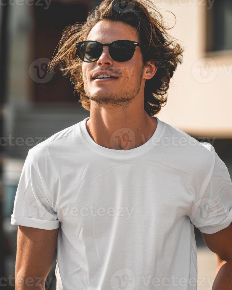A man with long hair and sunglasses wears a plain white t-shirt outdoors photo