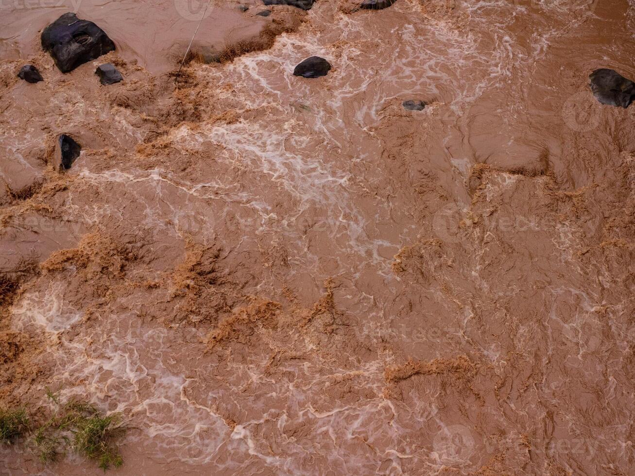 Close-up aerial view of the mighty Mekong River shows its muddy waterways flowing hard and fast during the rainy season. photo