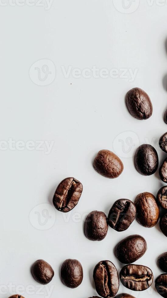Close-up of coffee beans scattered on a white surface photo