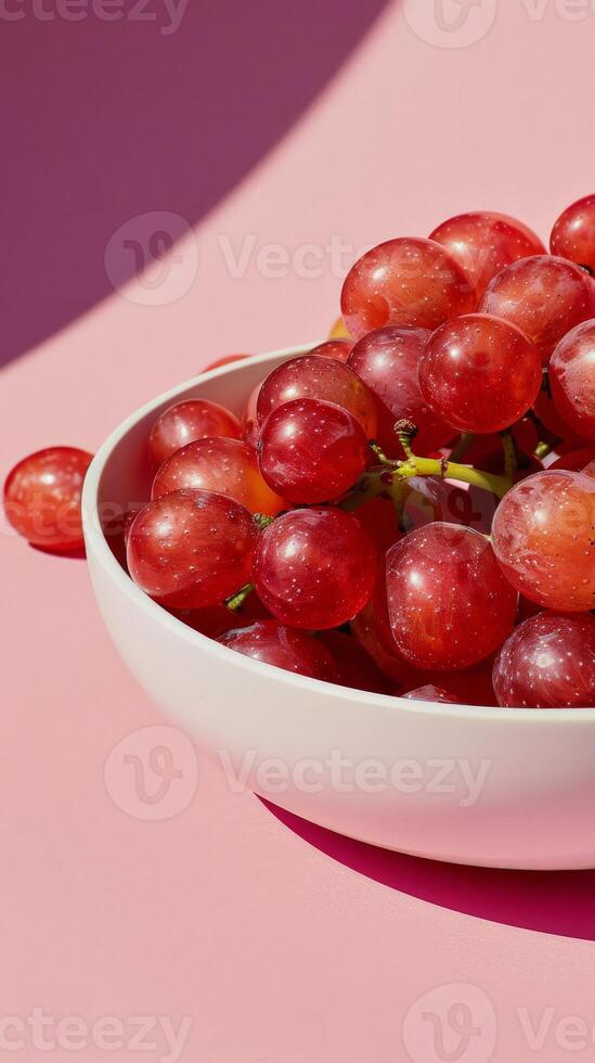 A close-up image of a bowl filled with red grapes photo