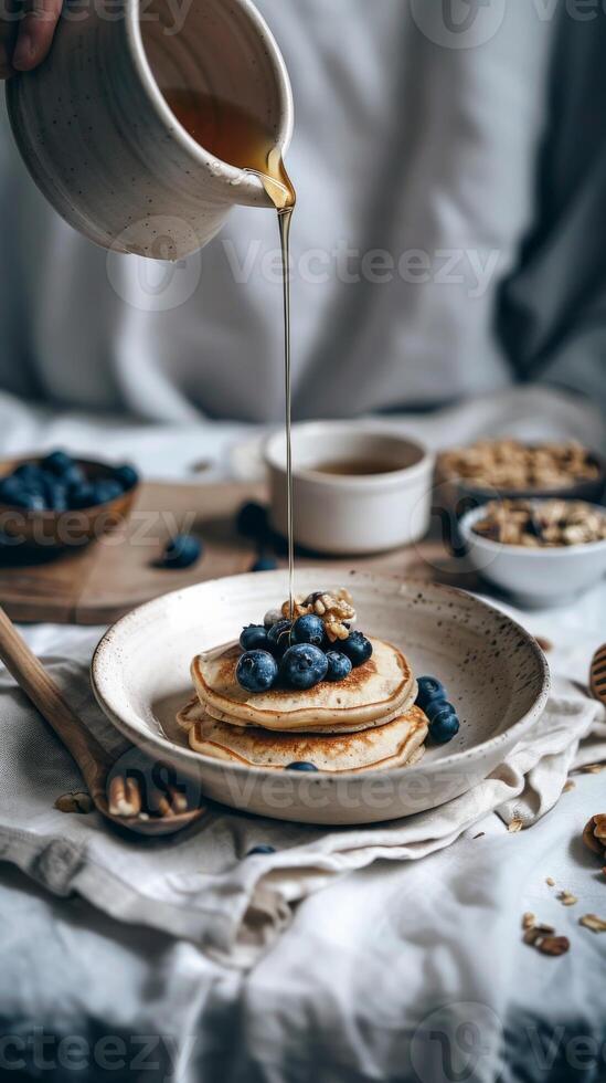 Stack of pancakes topped with blueberries and drizzled with honey photo