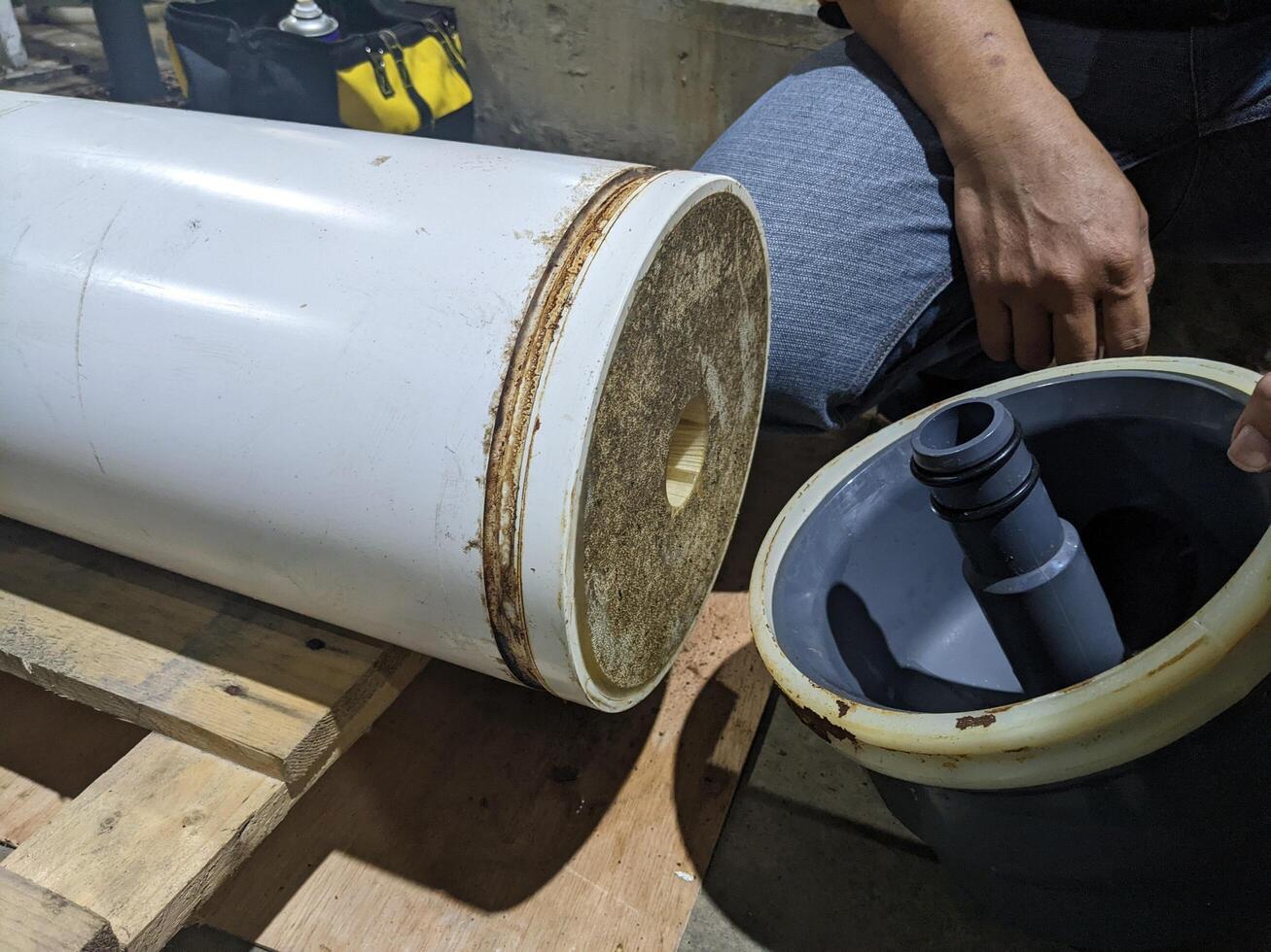 Inspection Water Ultra Filtration Membrane skid Maintenance. A close-up view of a water filter cylinder, featuring a white outer layer and a gray inner tube. photo