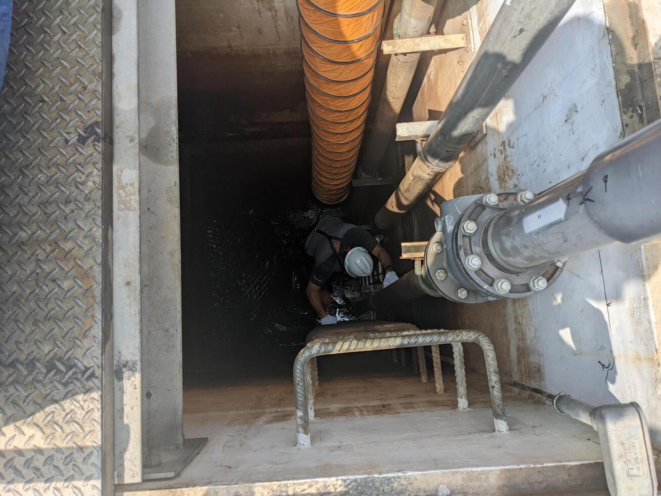 Two Workers Inspecting a Pipe Inside a Concrete Structure Confine space photo