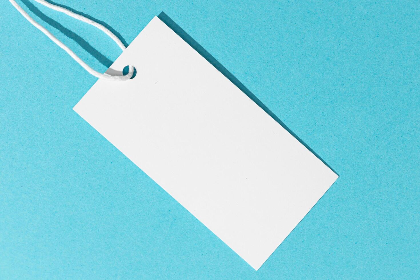 Blank white price tag isolated on blue background. template mock up photo