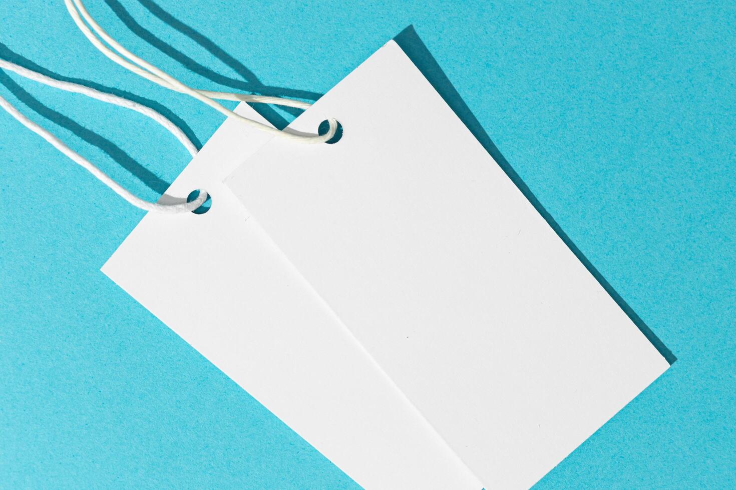 Blank white price tags isolated on blue background. template mock up photo