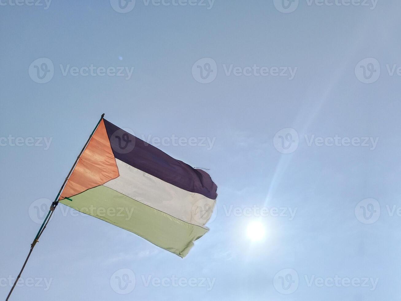 The Palestinian flag flies in the blue sky. photo