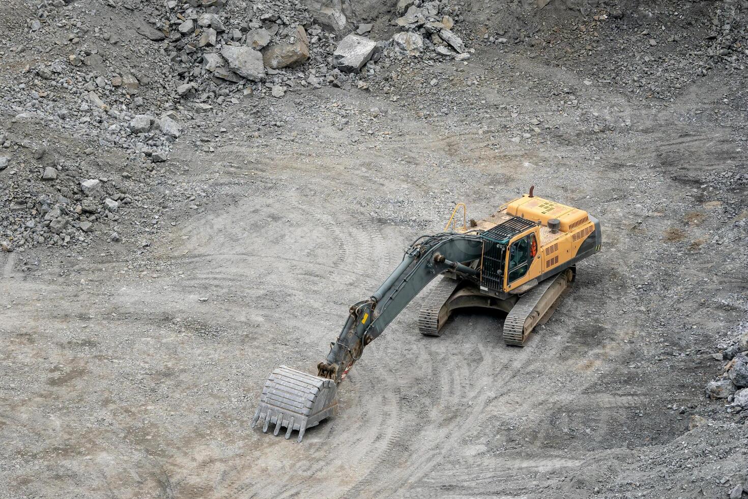 Mining in the granite quarry. Working mining machine - digger. Mining industry. photo