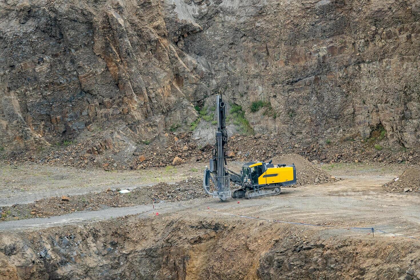 Opencast mining quarry with mining drilling machine. Mining in the granite quarry. Mining industry. photo