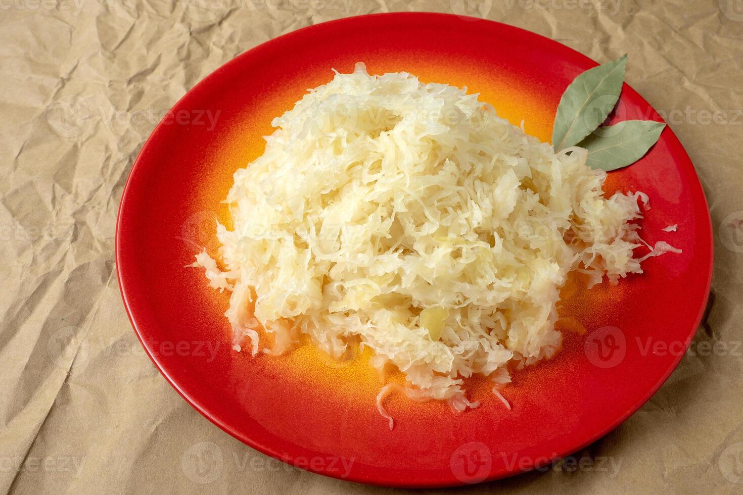 Fermented cabbage. Red plate of sauerkraut photo