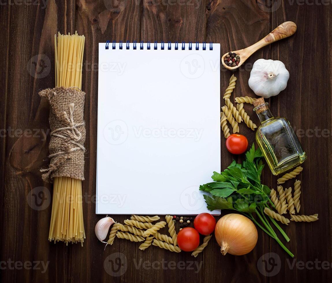 Tomato, pasta, garlic, parsley and empty notebook photo
