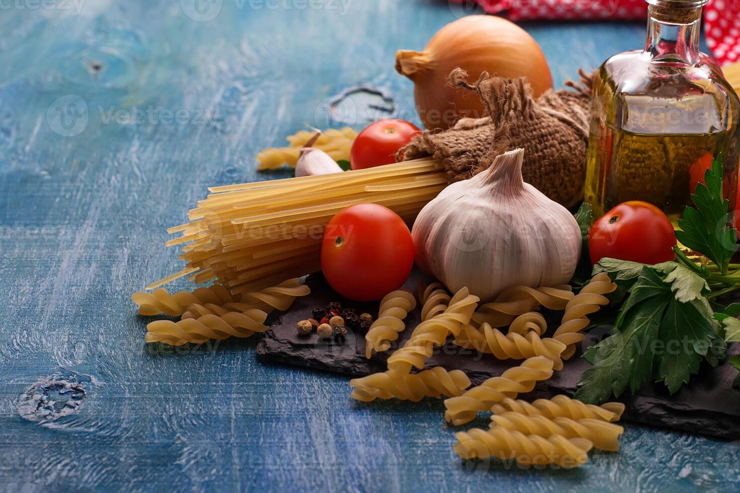 Tomato, uncooked pasta, garlic, parsley photo