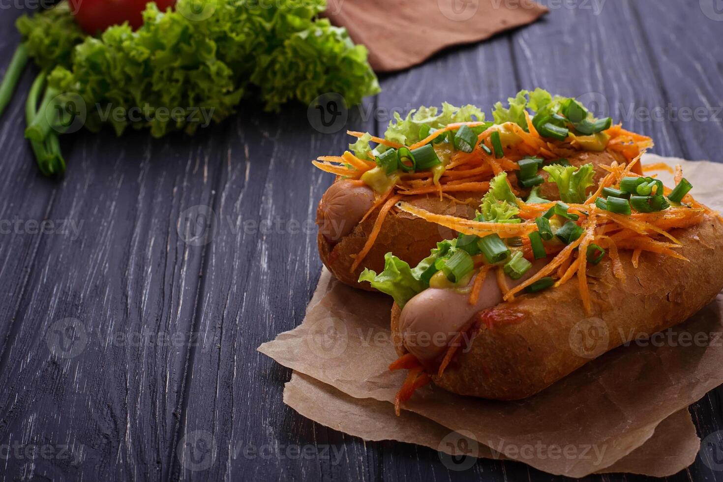 Hot dog with sausage, carrot, onion, lettuce photo