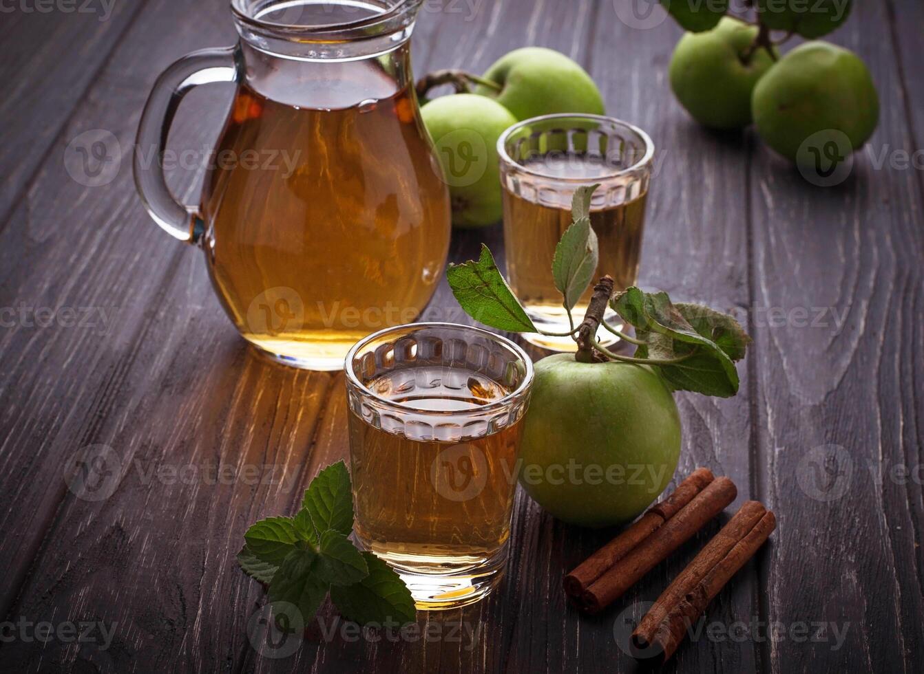 Glasses with apple juice on wooden table photo