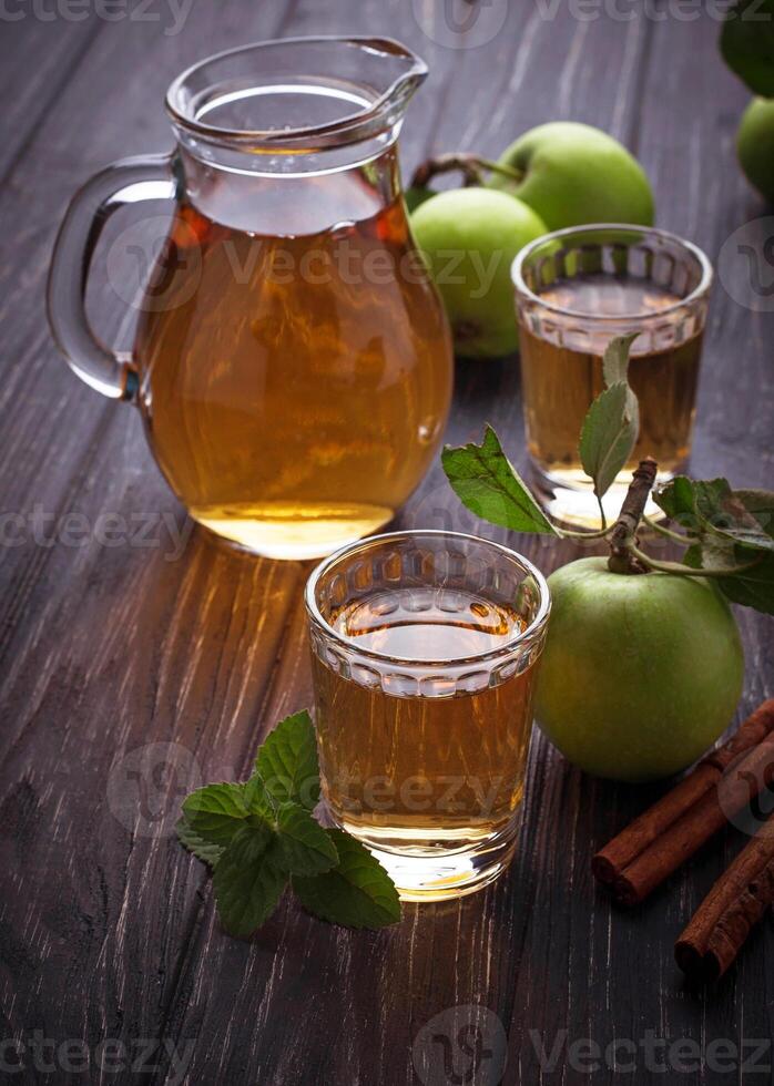 Glasses with apple juice on wooden table photo