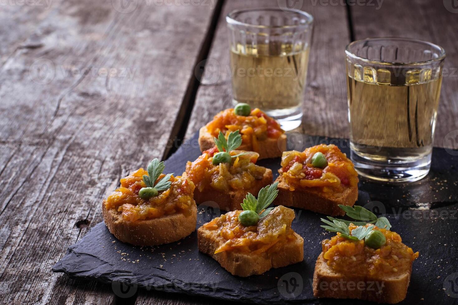 Canape with eggplant caviar and glasses of wine photo