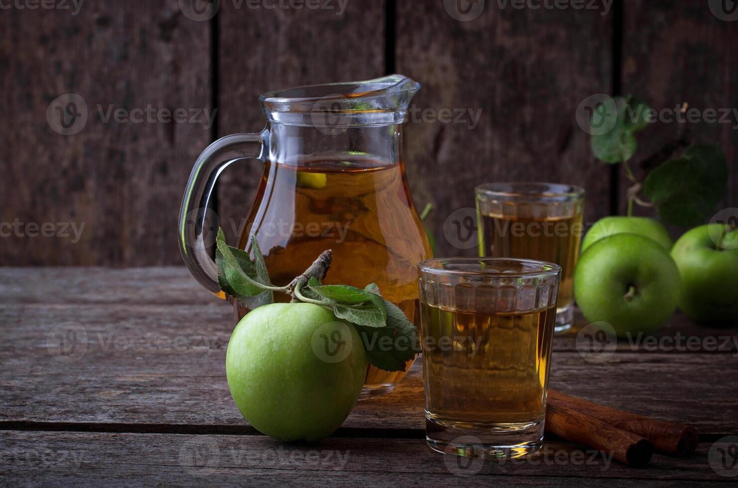 Glasses with apple juice on wooden table photo