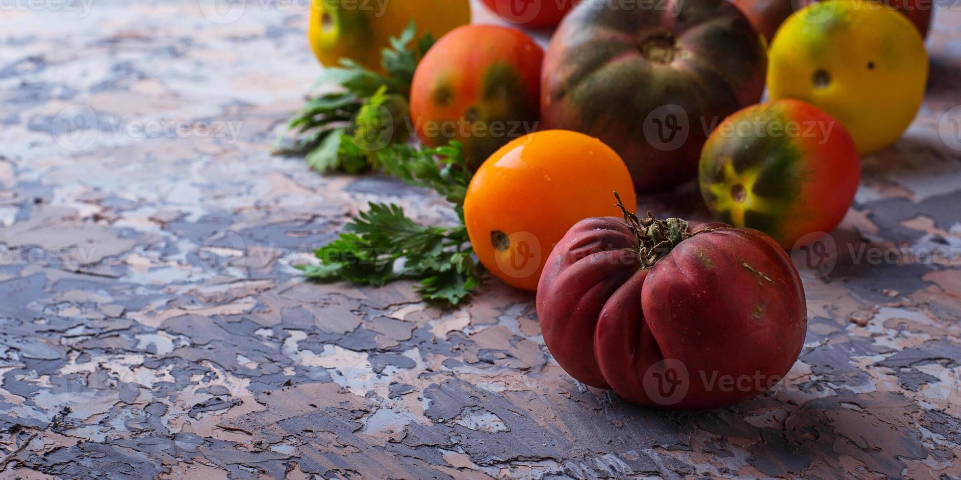 Different sort of tomato on concrete background photo