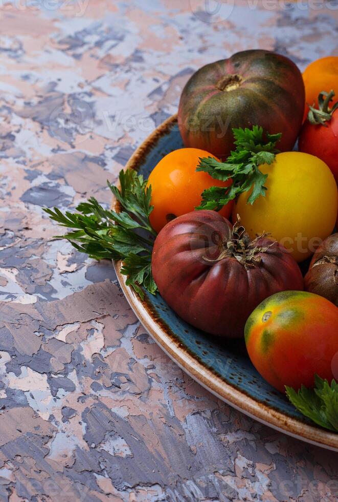 Different sort of tomato on concrete background photo