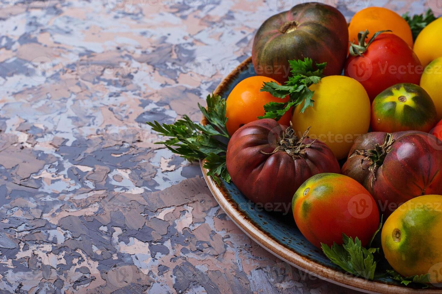 Different sort of tomato on concrete background photo