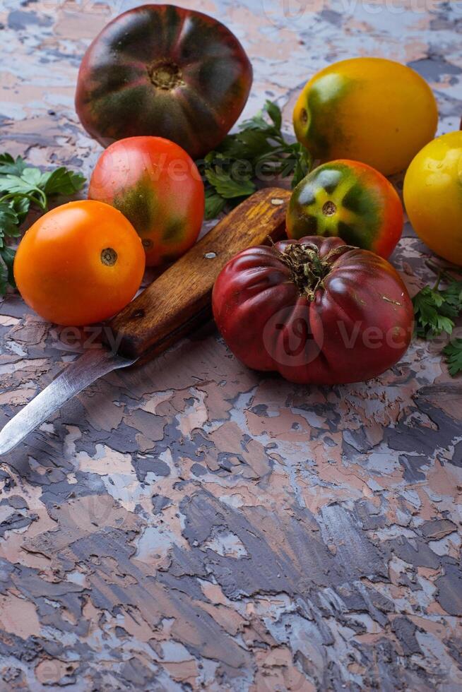 Different sort of tomato on concrete background photo