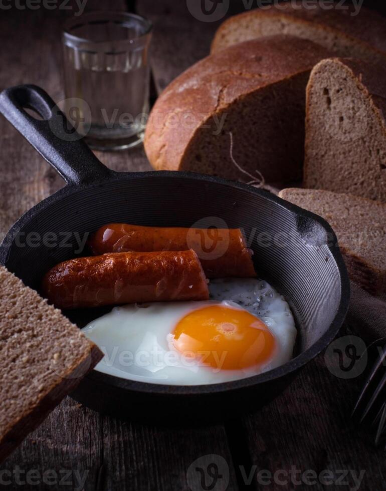 Fried eggs with sausages in a pan photo