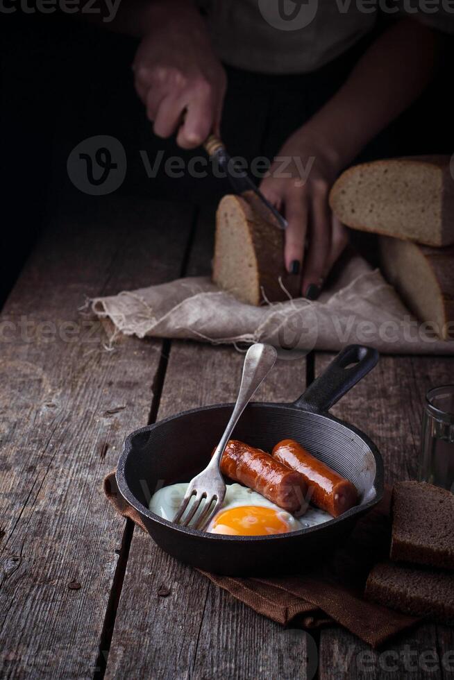 Fried eggs with sausages in a pan photo