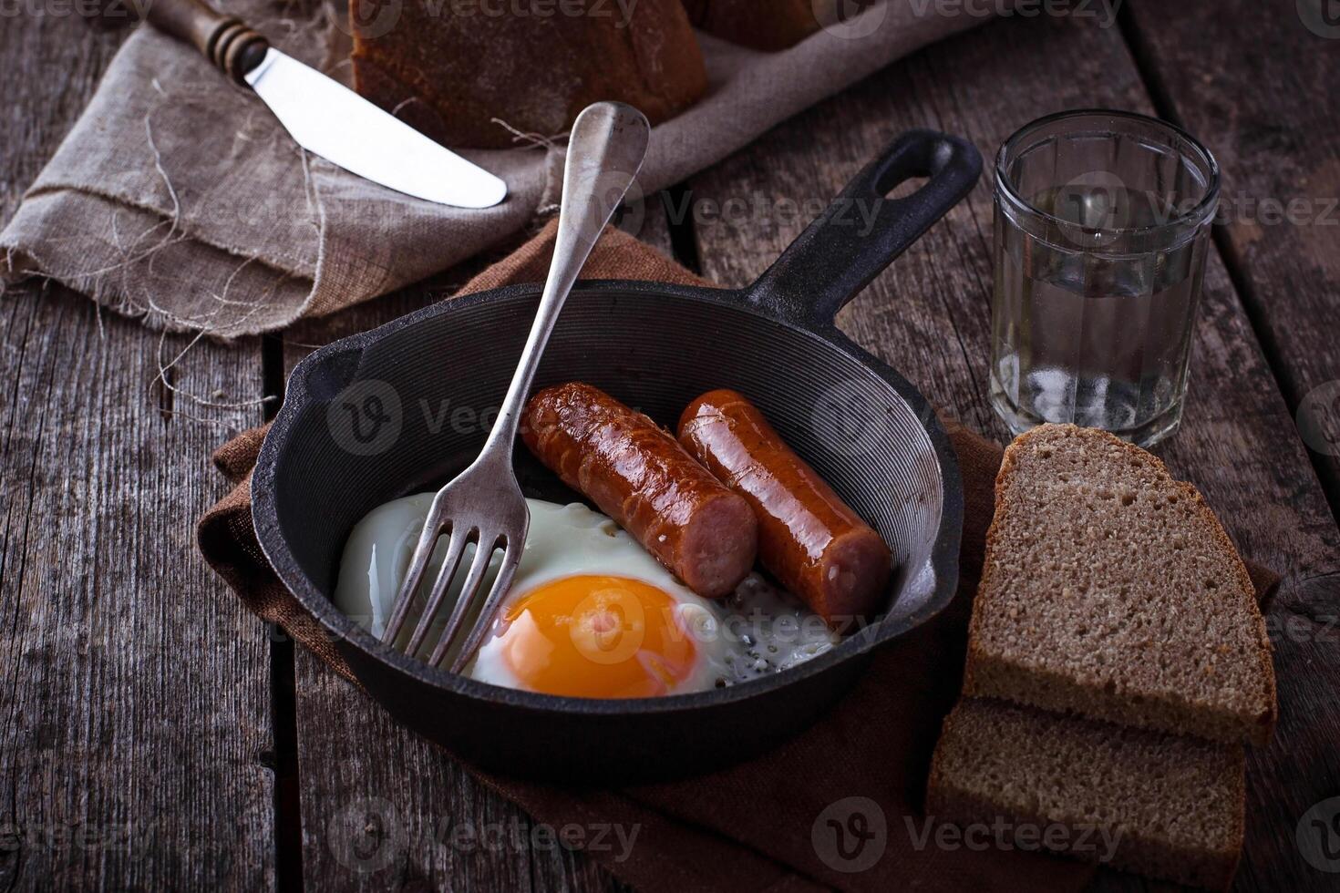 Fried eggs with sausages in a pan photo