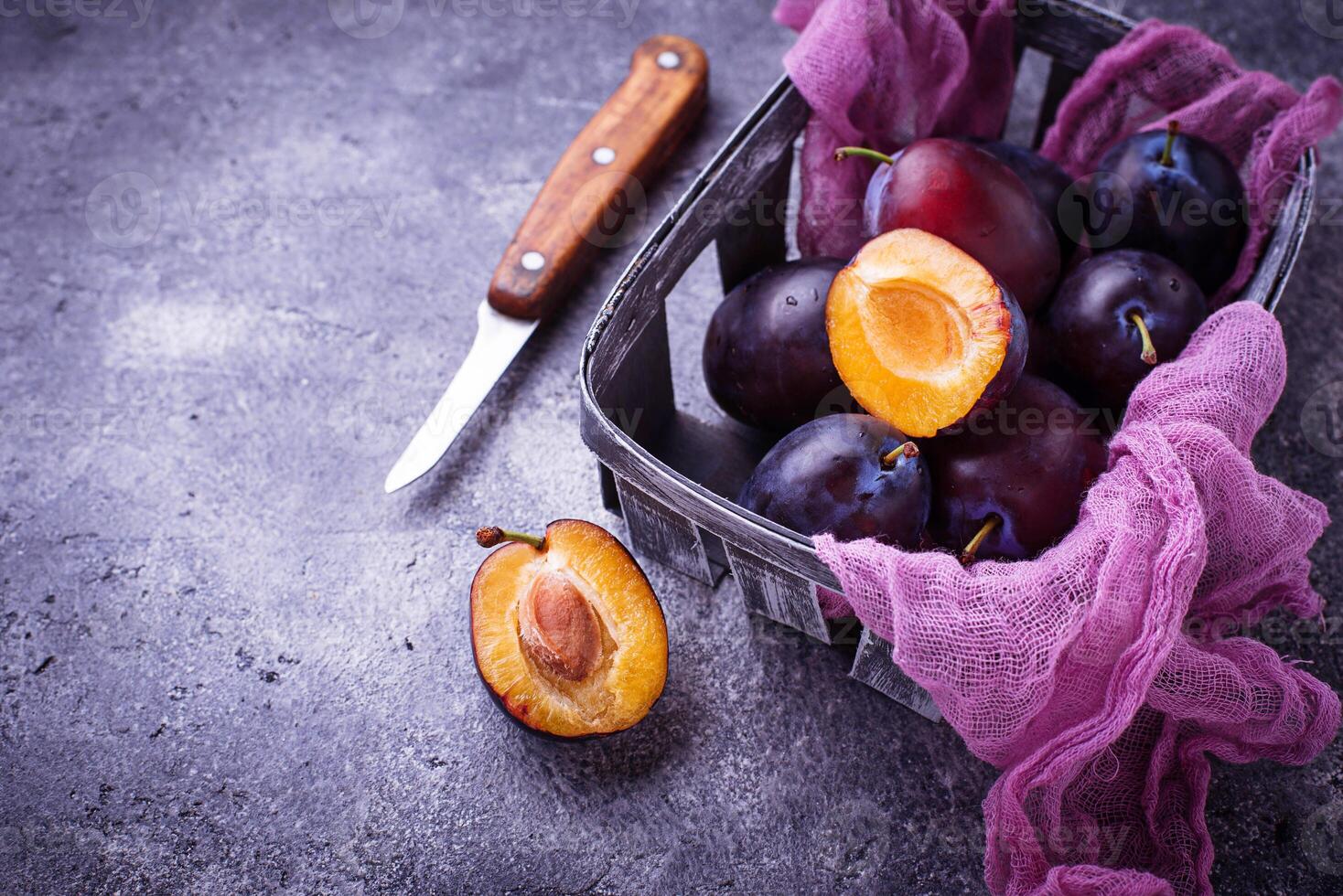 Fresh sweet plums on concrete background photo