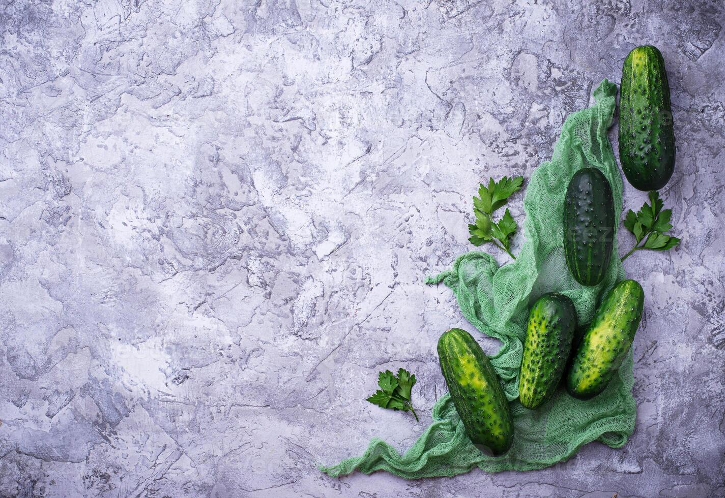 Fresh cucumbers on concrete background photo
