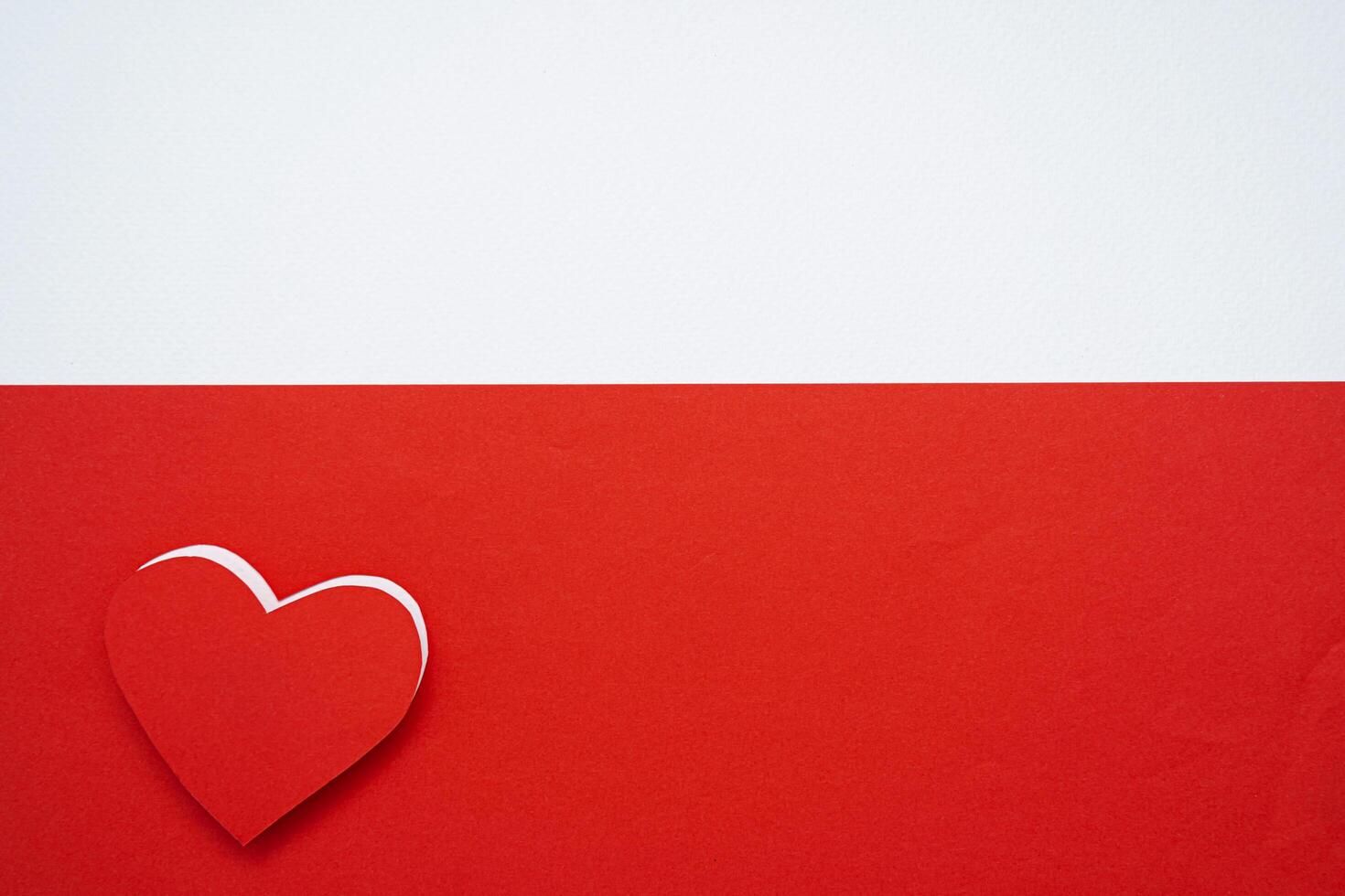 Red paper hearts isolated on red background On the bottom left there is an empty space photo
