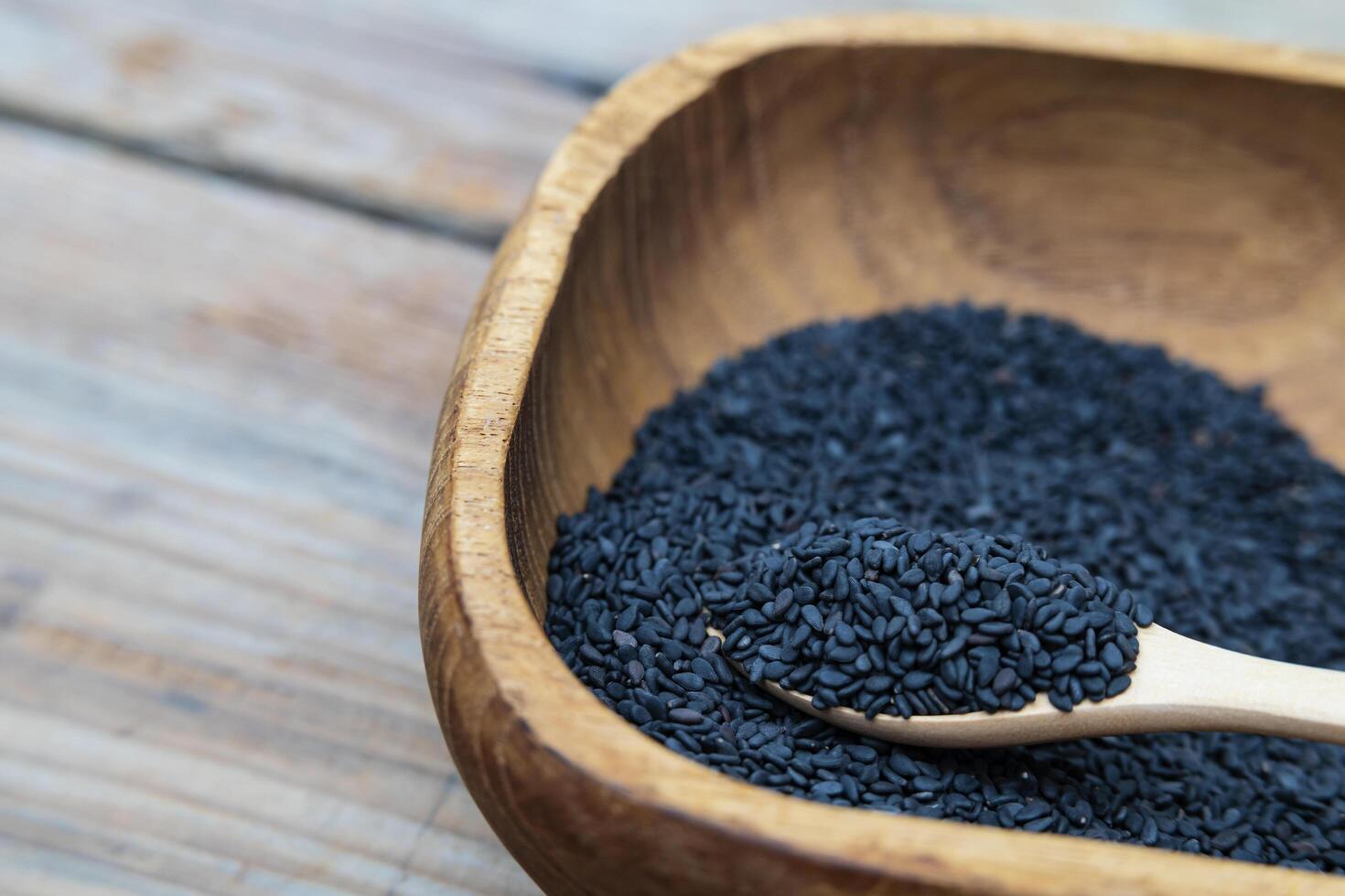 Heap of black Sesame close-up shot on wooden background photo