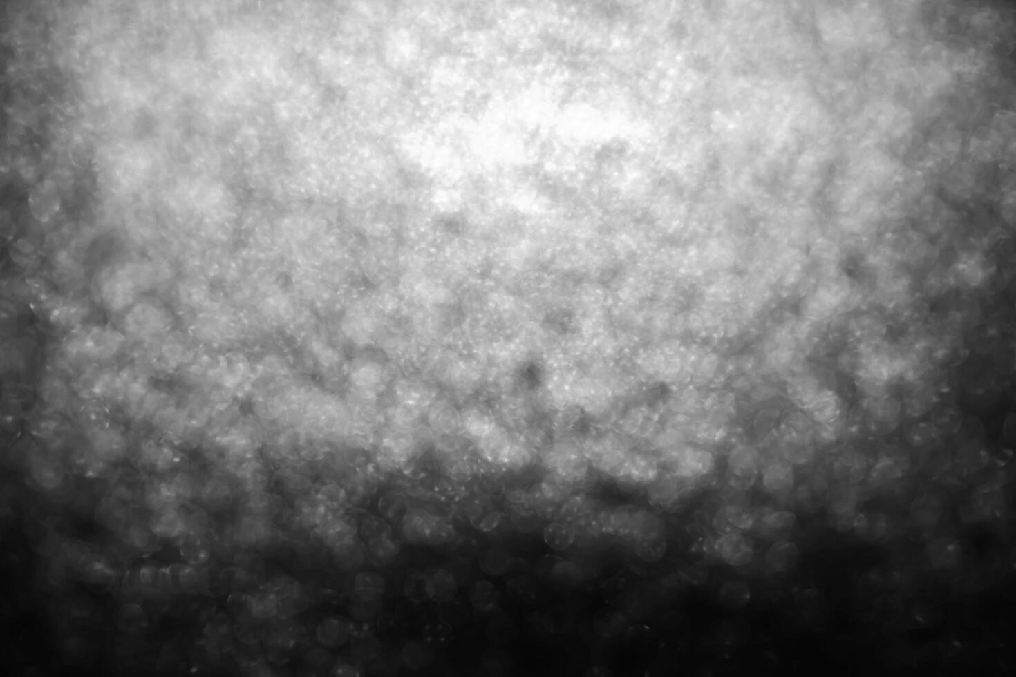 Bokeh lights on black background, shot of flying drops of water in the air, defocused water drops levitation on dark, blurred photo