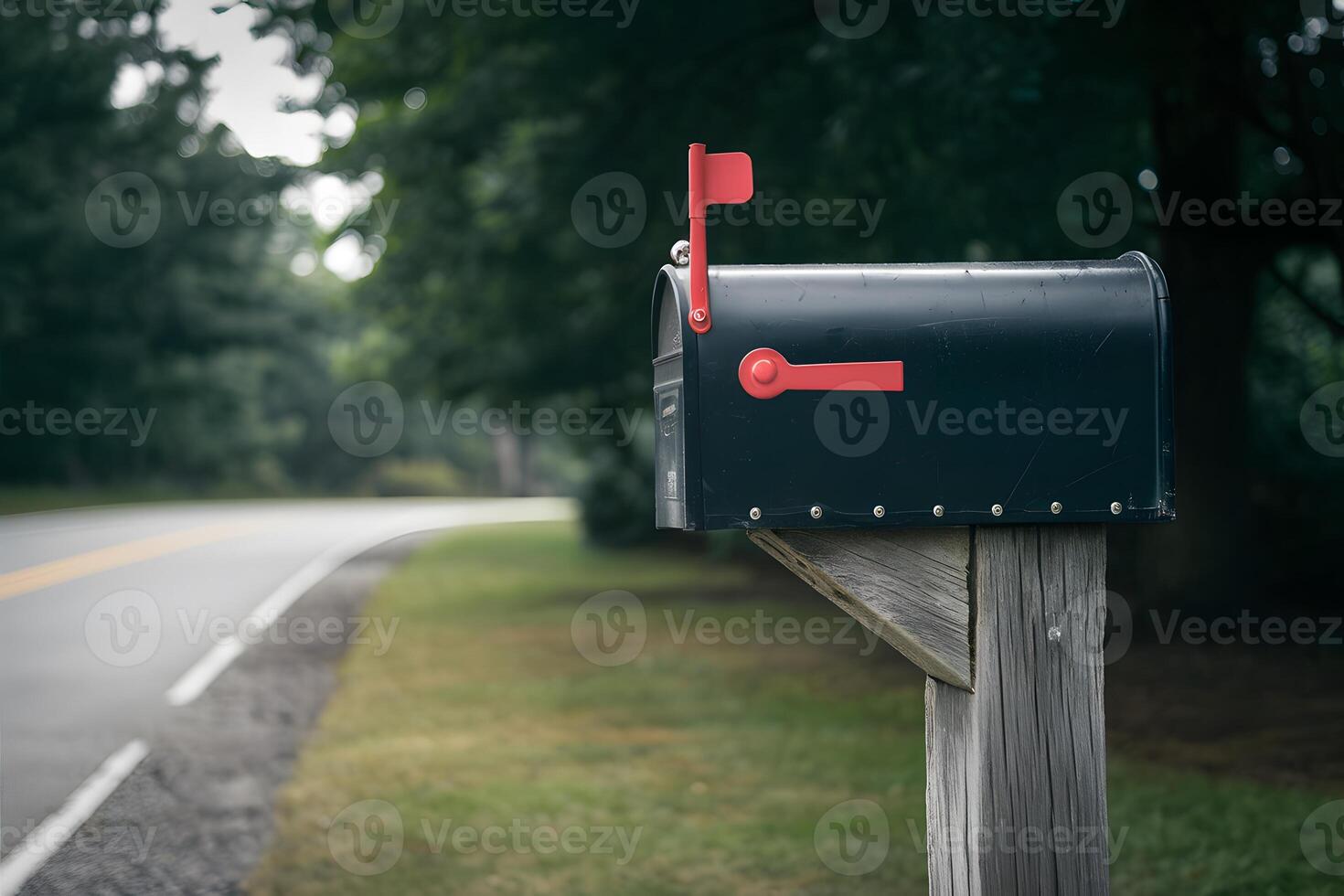 Black mailbox on wooden post by roadside with blurred background photo