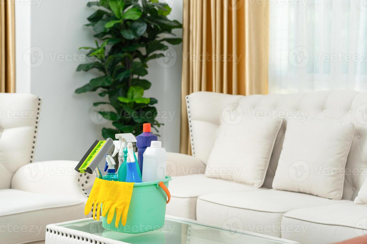 Set of cleaning supplies on the table in room, Bucket with cleaning products, Household equipment photo