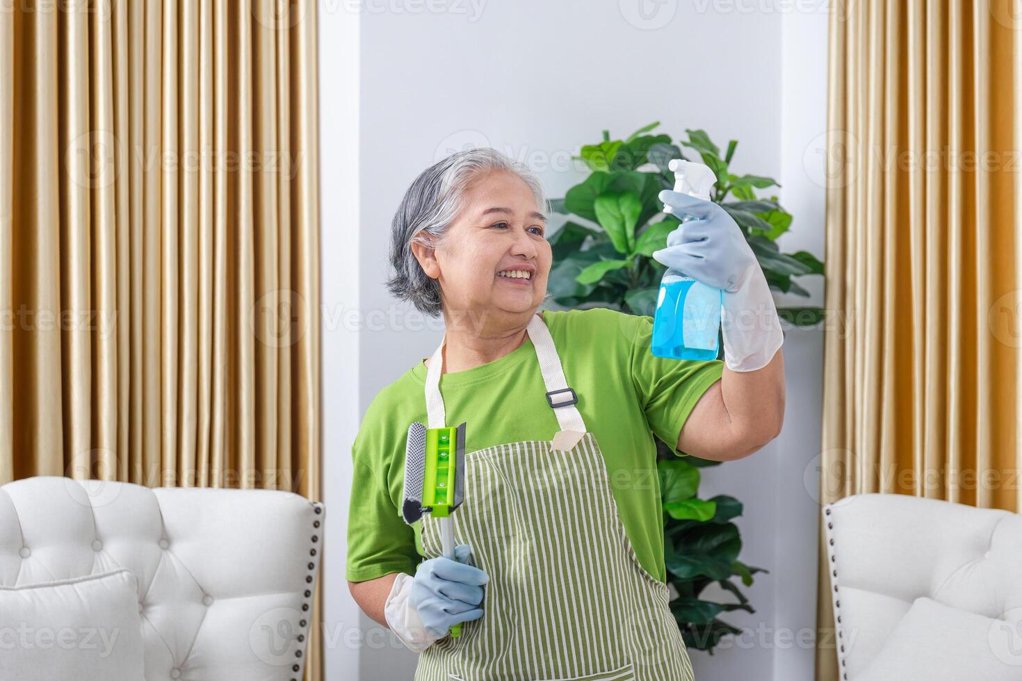 Cheerful senior woman housekeeping, Professional female housekeeper with cleaning tools, Cleaning service cleans house photo