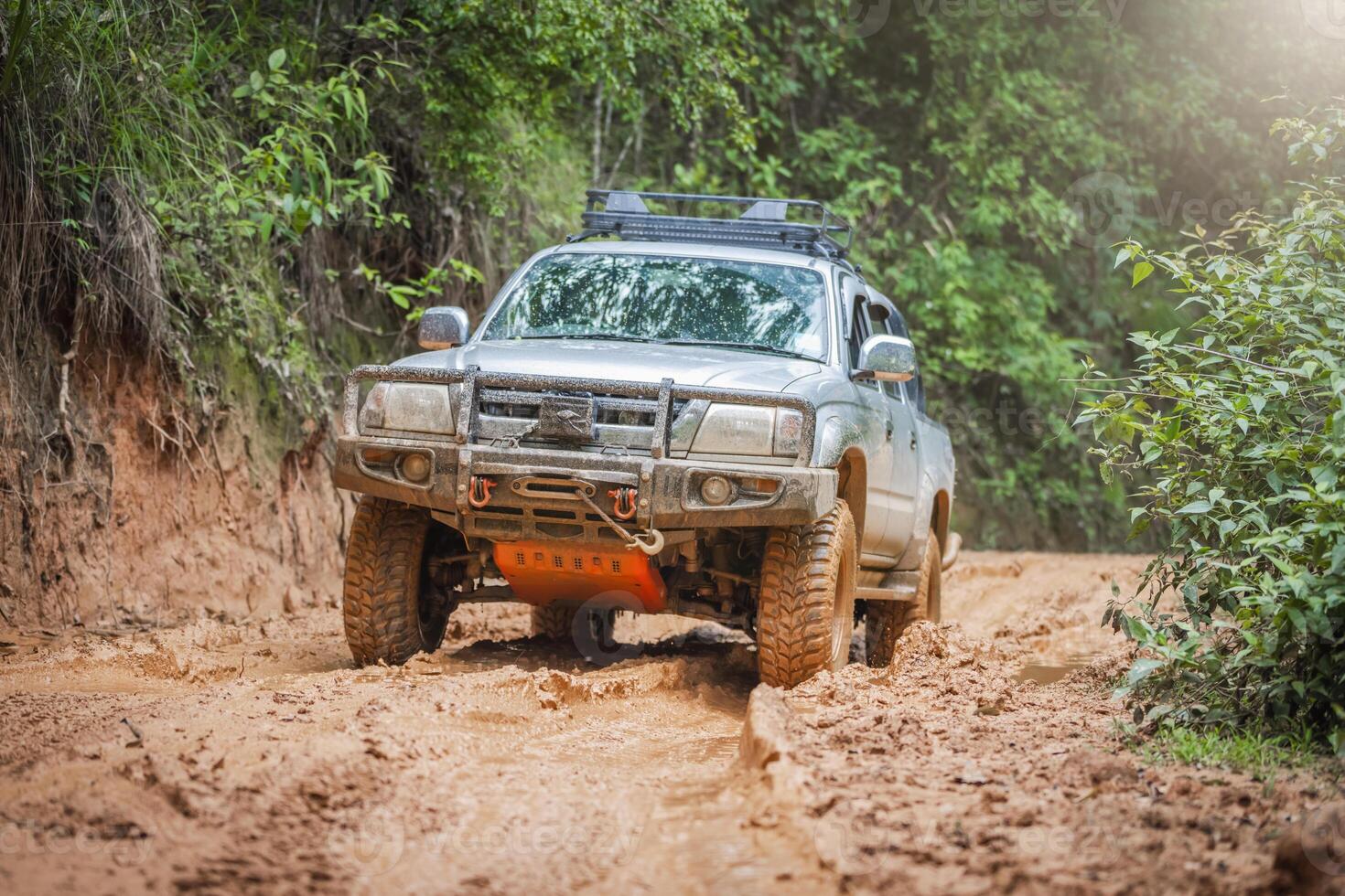 Cars running on off-road roads and splashing mud on natural paths. Off-road travel on muddy road. Offroad travel and driving concept, Wheel closeup in a countryside landscape with a muddy road. photo