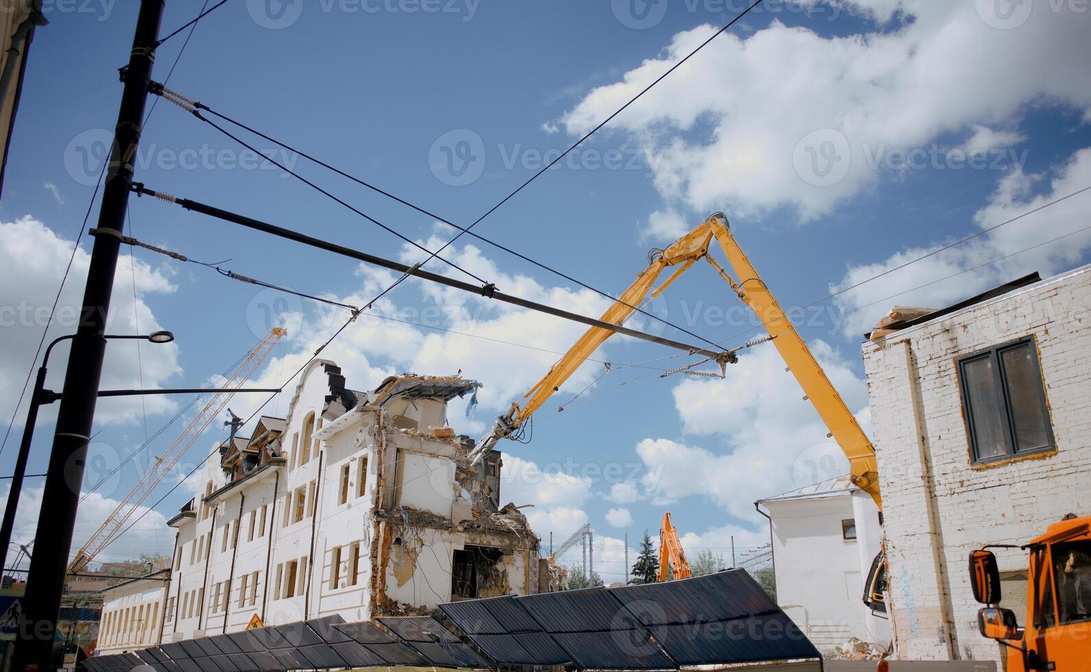 Excavator for demolition of buildings with a hydraulic crusher. The concept of demolition of buildings using excavators. photo