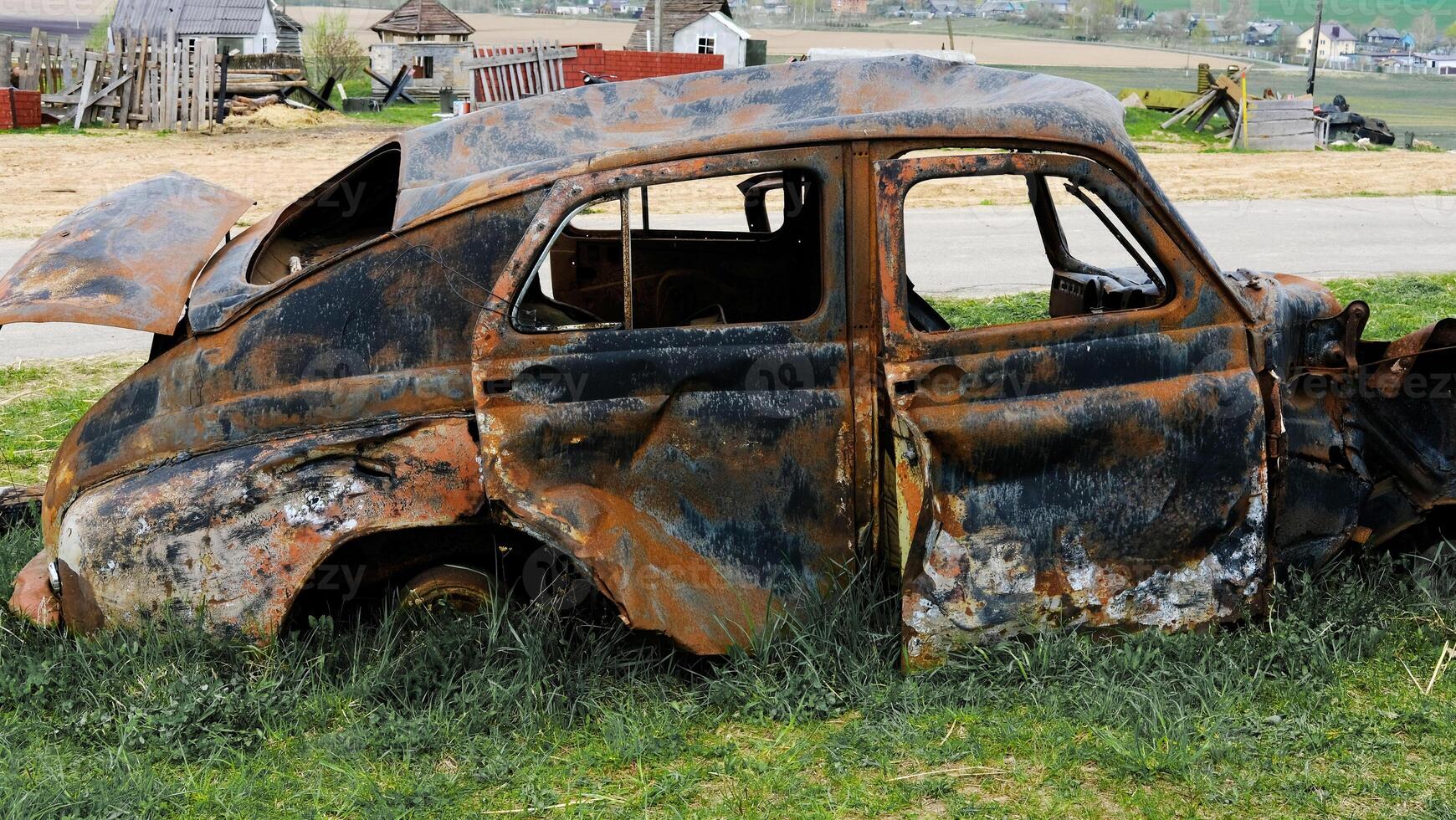Rusty Abandoned Car in Rural Setting photo