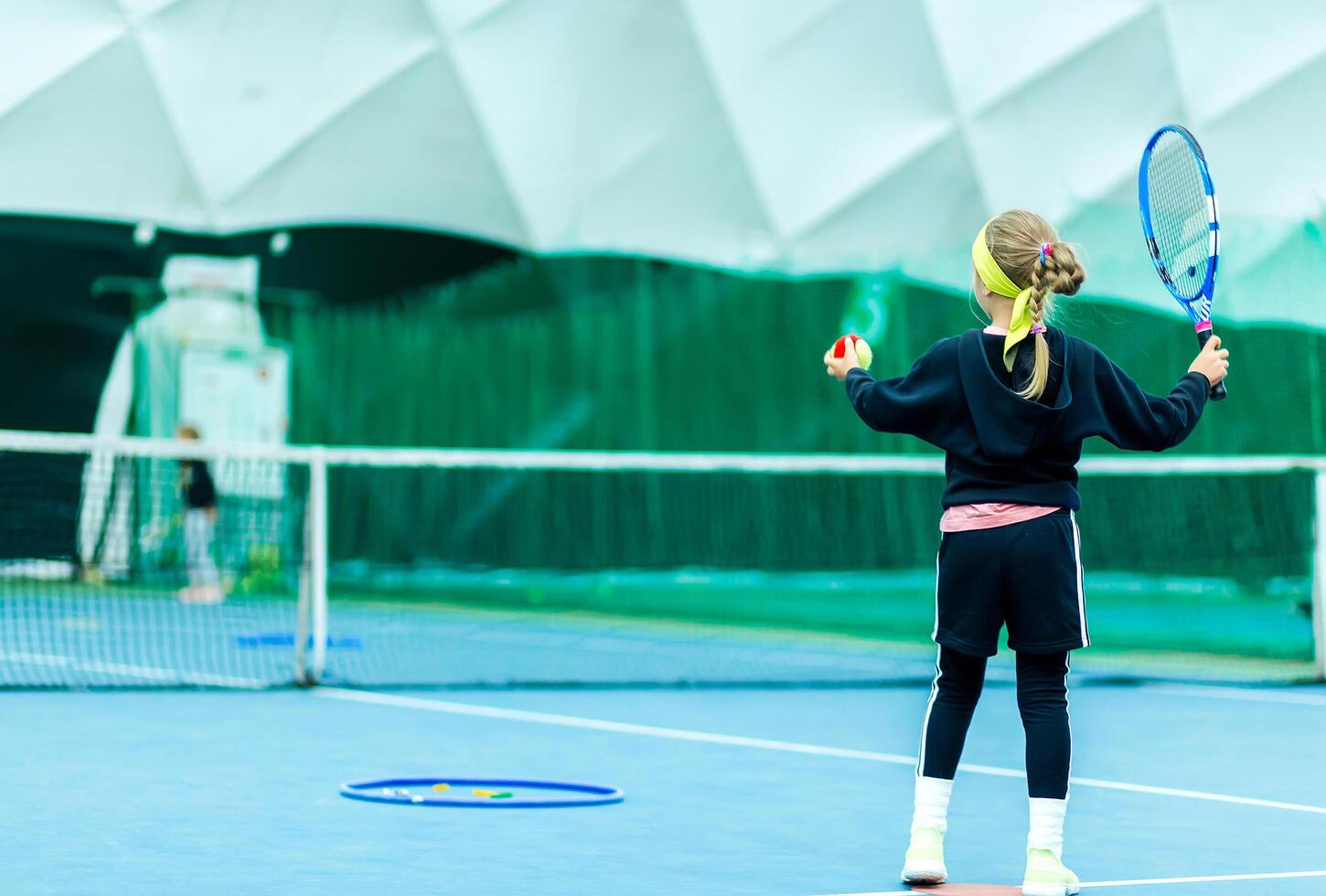 Child Preparing to Serve on Tennis Court. Minsk, Belarus - October 18, 2021 photo