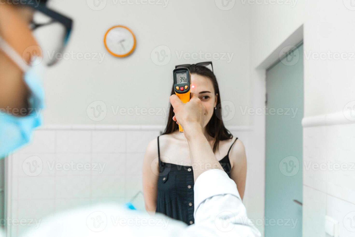 Temperature Check with Infrared Thermometer on Woman photo