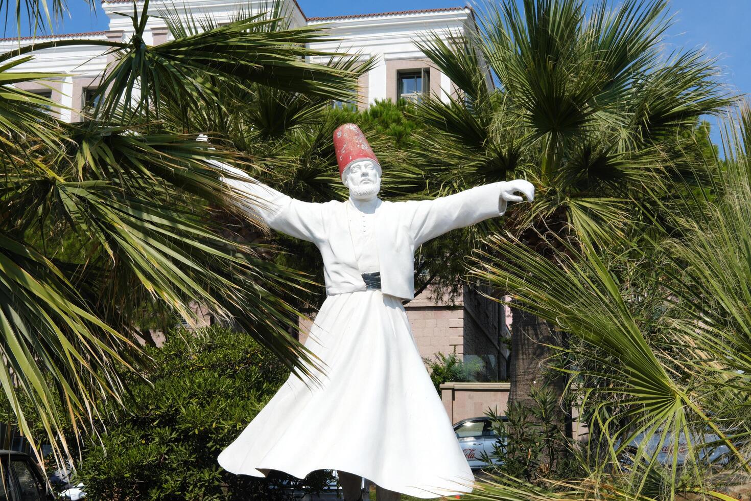 Whirling Dervish Sculpture Amongst Palm Trees. Cunda, Turkey - August 26, 2023 photo