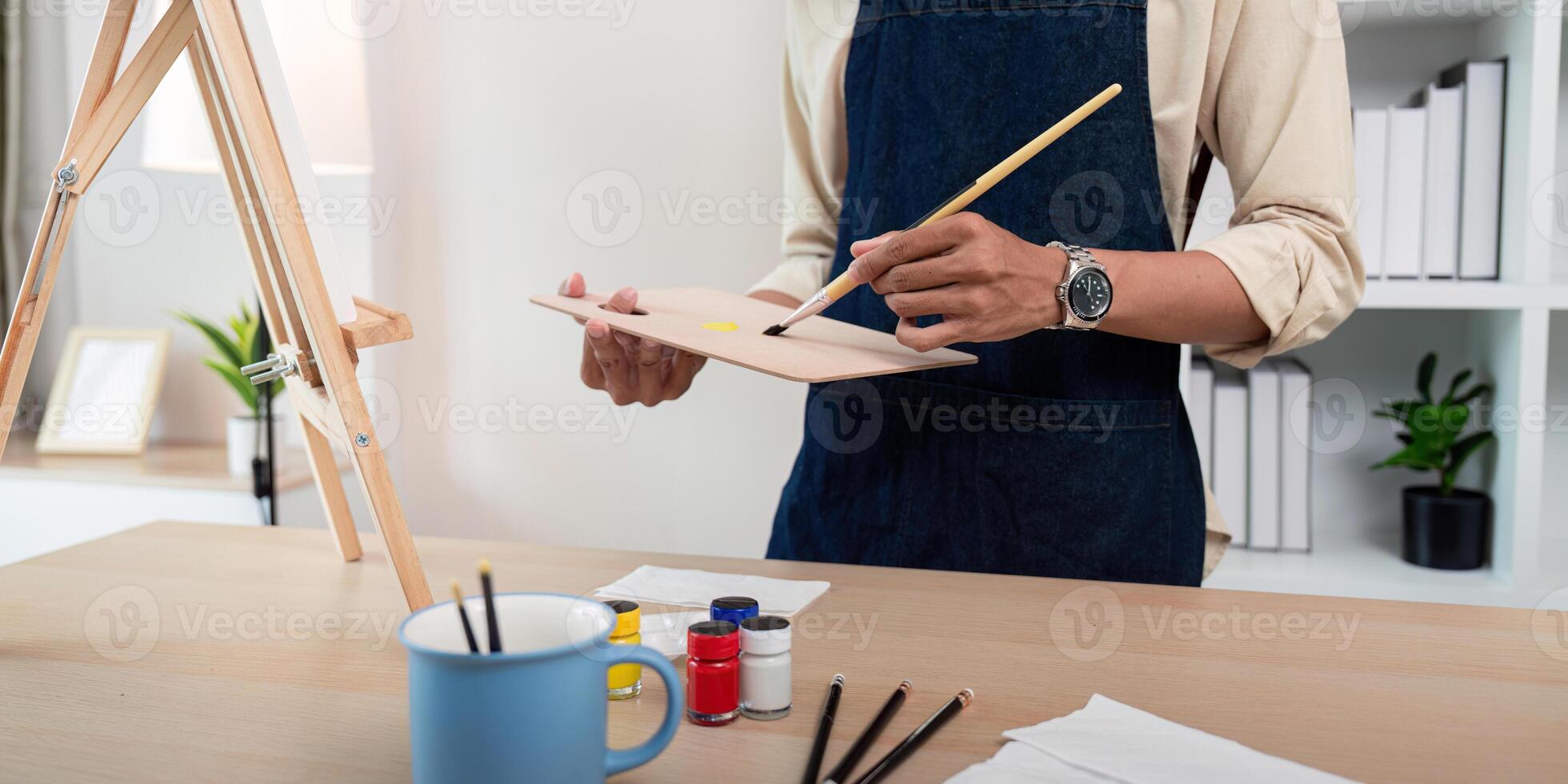 Artist Painting on Canvas in Studio with Art Supplies and Easel, Creative Workspace Concept photo