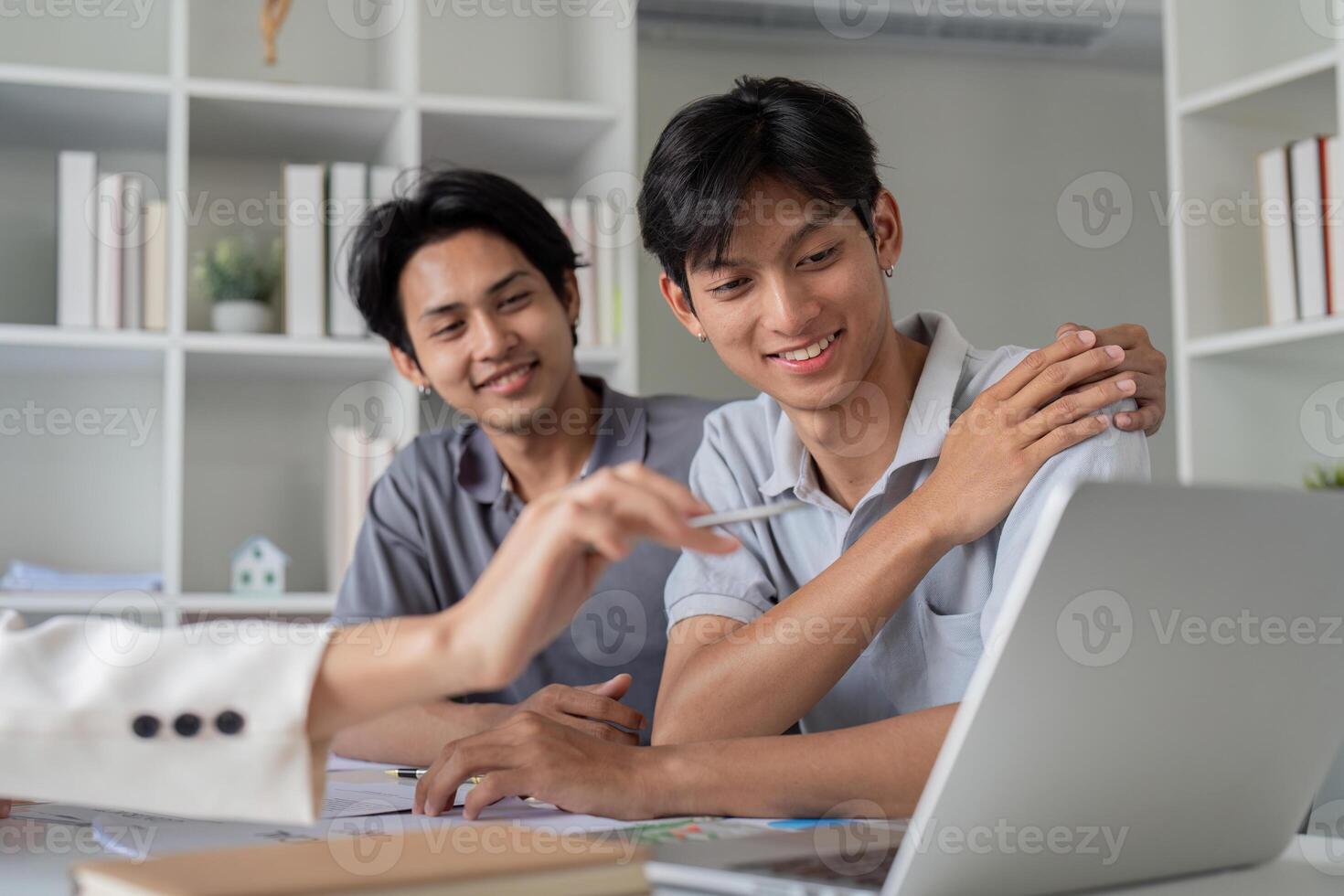 Gay Couple Planning Finances Together at Home with Laptop and Documents, Discussing Future Investments and Budgeting photo